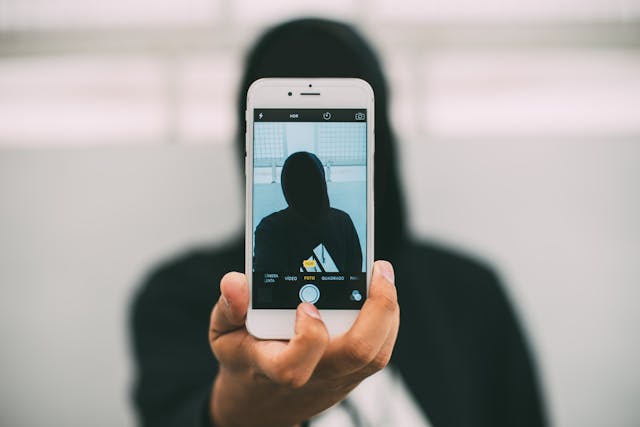 Comunicación en la era virtual Persona ensombrecida sacándose una selfie