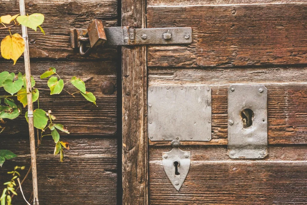 Fotografía de detalle de puerta vieja con un candado. Eficiencia y eficacia del acceso a la justicia